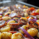 Sheet Pan Gnocchi Sausage Recipe – A Quick, Delicious, and Easy Meal 5 Steamy close-up of sheet pan gnocchi sausage with crispy edges, red onions, and roasted bell peppers